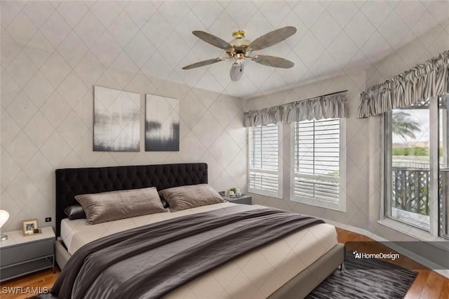 bedroom with hardwood / wood-style floors, multiple windows, and ceiling fan