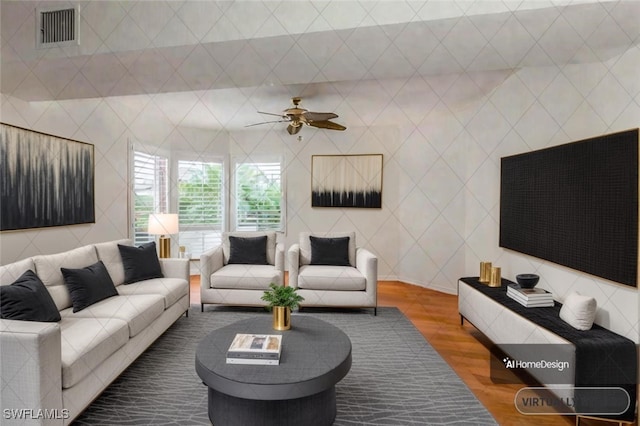 living room featuring ceiling fan, wood-type flooring, and tile walls