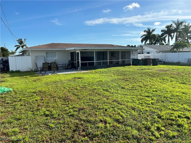 back of house featuring a patio, a yard, and a sunroom