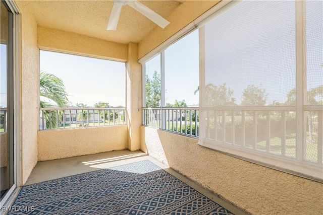 unfurnished sunroom featuring ceiling fan