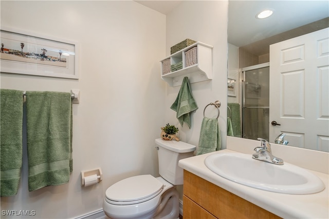 bathroom with vanity, toilet, and a shower with door