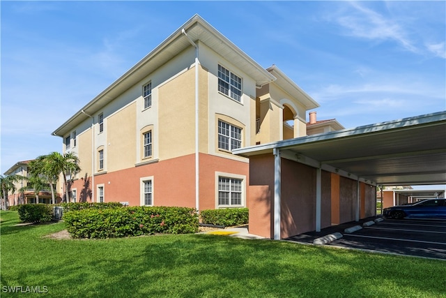 view of side of home featuring a yard and a carport