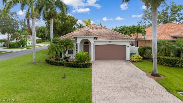 mediterranean / spanish home featuring a garage and a front yard