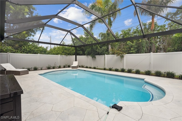 view of pool with a patio and glass enclosure