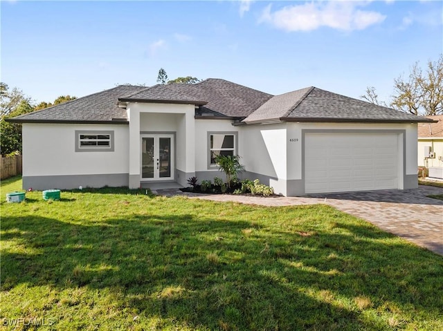 prairie-style house featuring decorative driveway, french doors, stucco siding, an attached garage, and a front lawn