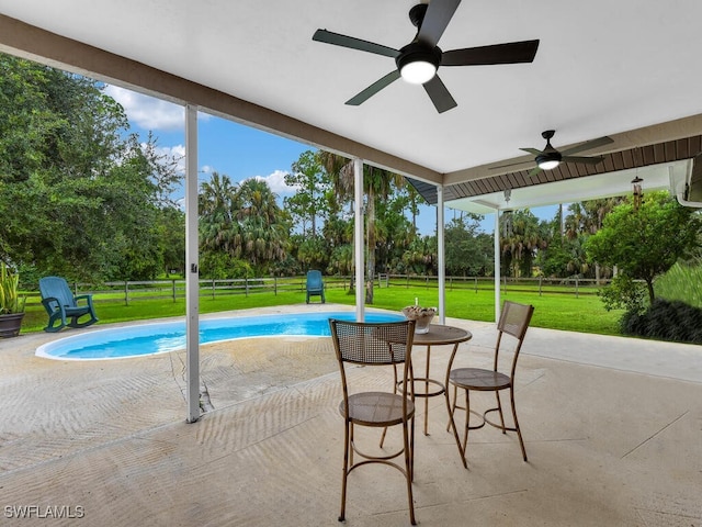 view of pool featuring ceiling fan, a lawn, and a patio area