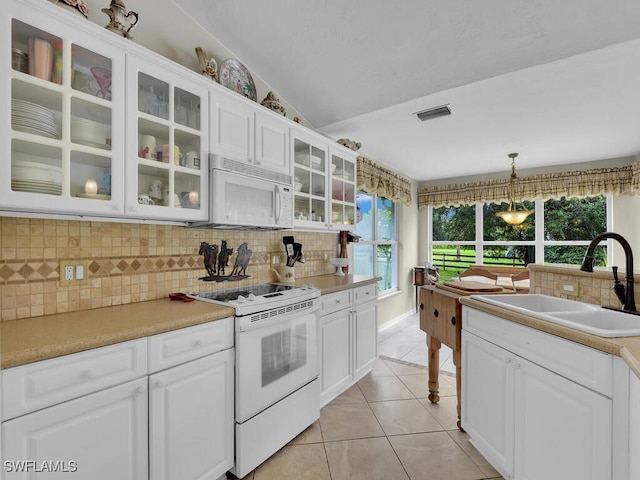 kitchen featuring white cabinetry, sink, backsplash, decorative light fixtures, and white appliances