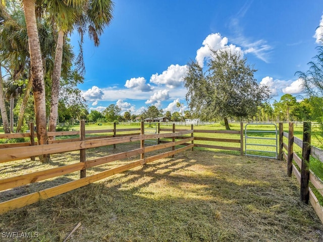 view of gate with a yard and a rural view