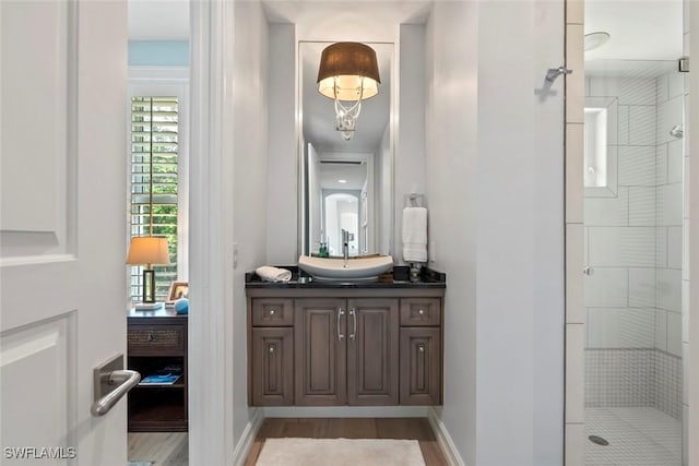 bathroom featuring hardwood / wood-style flooring, vanity, and a shower with door