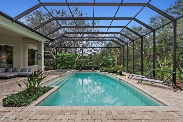 view of swimming pool with glass enclosure, a patio area, and an in ground hot tub