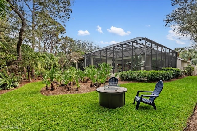 view of yard featuring a lanai and an outdoor fire pit