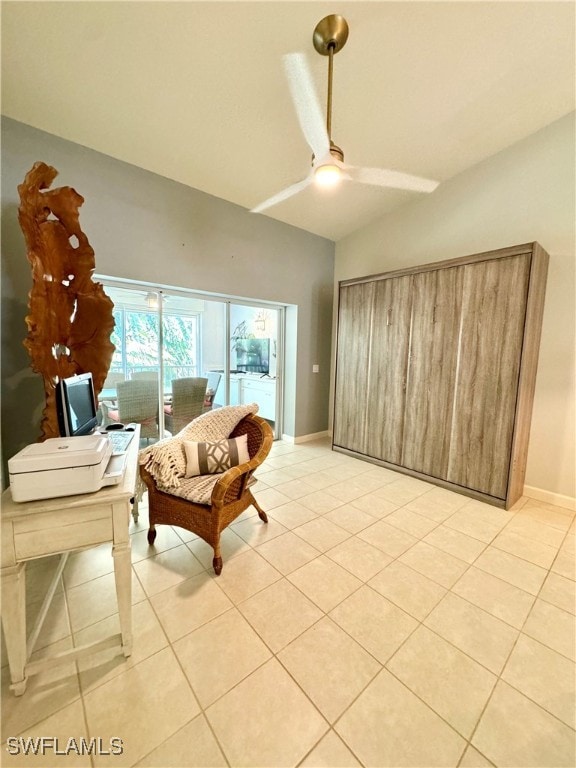 sitting room featuring ceiling fan, light tile patterned flooring, and vaulted ceiling