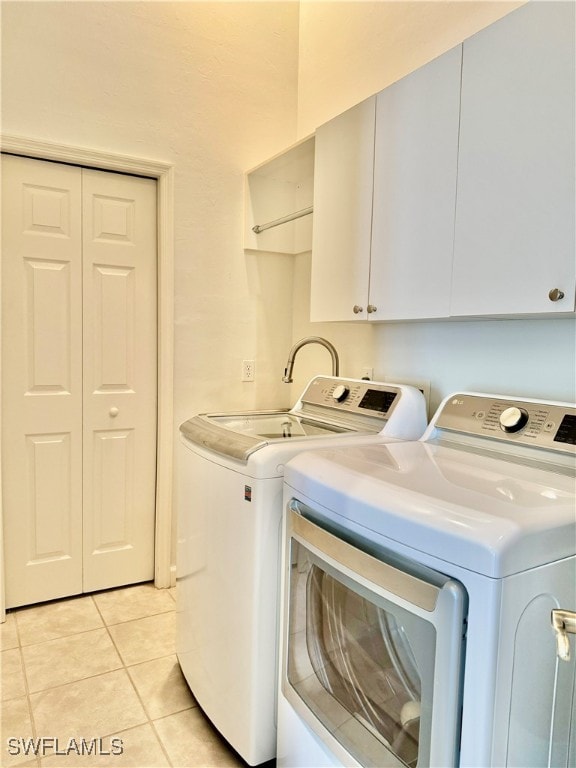 laundry area featuring cabinets, separate washer and dryer, and light tile patterned floors