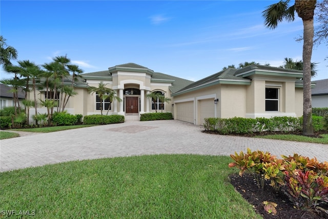 view of front of property with a garage and a front lawn