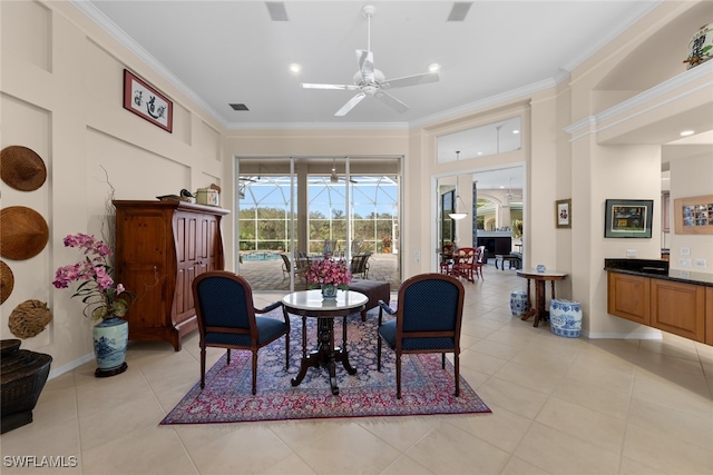 sitting room with ceiling fan, light tile patterned floors, and crown molding