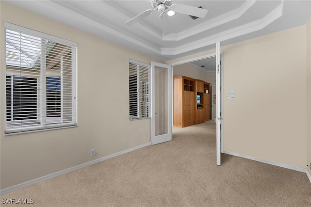 unfurnished room with french doors, light colored carpet, a raised ceiling, and ceiling fan