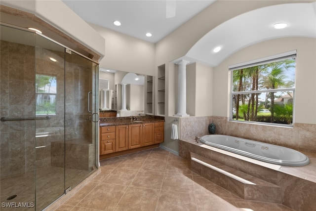 bathroom featuring tile patterned flooring, shower with separate bathtub, vanity, and decorative columns