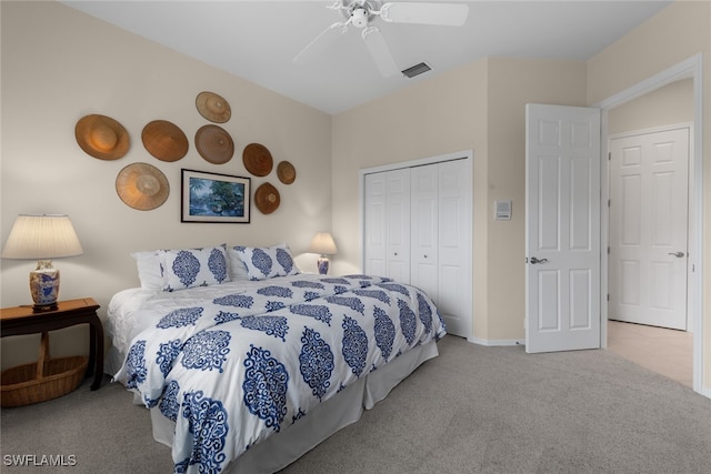 bedroom with ceiling fan, light colored carpet, and a closet