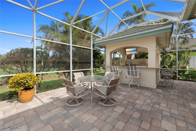 view of patio / terrace with glass enclosure and exterior bar