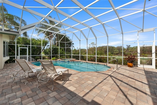 view of pool featuring a lanai, an in ground hot tub, and a patio