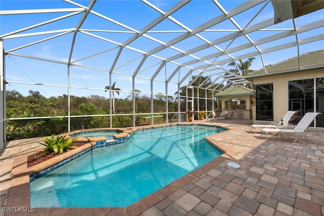 view of swimming pool with glass enclosure, an in ground hot tub, and a patio area