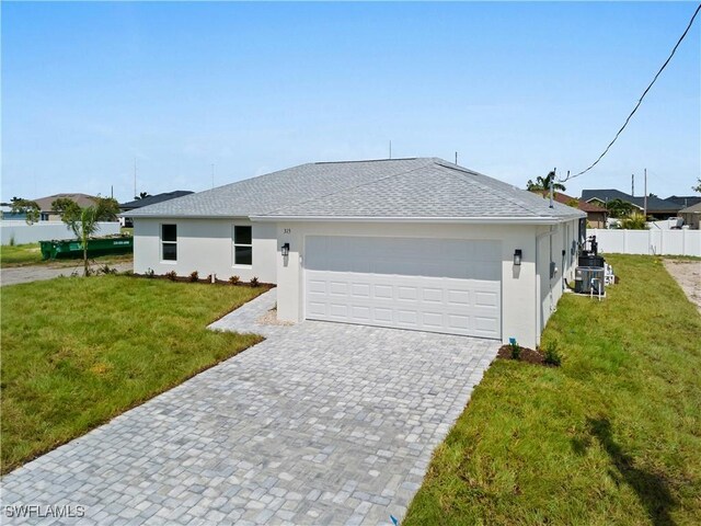 single story home featuring a garage and a front lawn