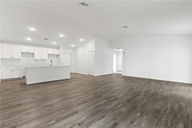 unfurnished living room featuring lofted ceiling, dark hardwood / wood-style floors, and sink