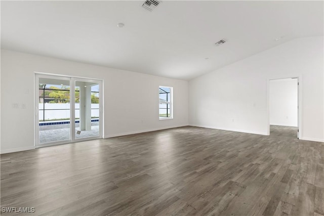 spare room with vaulted ceiling and dark hardwood / wood-style flooring