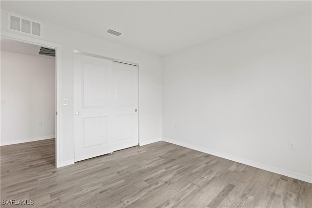 unfurnished bedroom with a closet and light hardwood / wood-style flooring