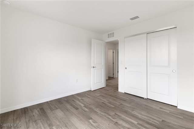 unfurnished bedroom featuring hardwood / wood-style flooring and a closet