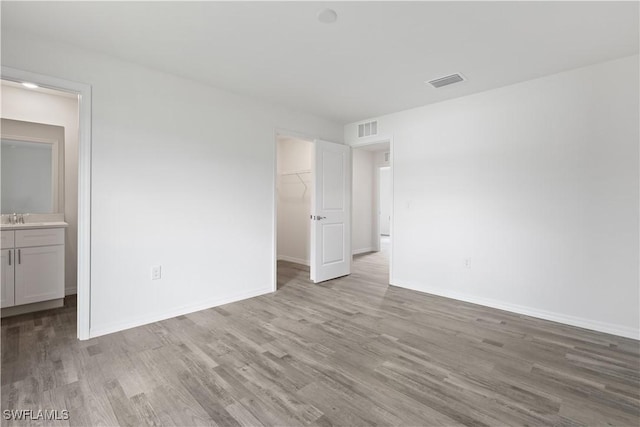 spare room with sink and light hardwood / wood-style floors