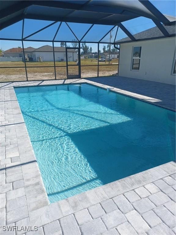 view of pool with a patio and glass enclosure