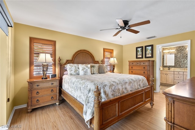 bedroom featuring ceiling fan, connected bathroom, light hardwood / wood-style floors, and a closet