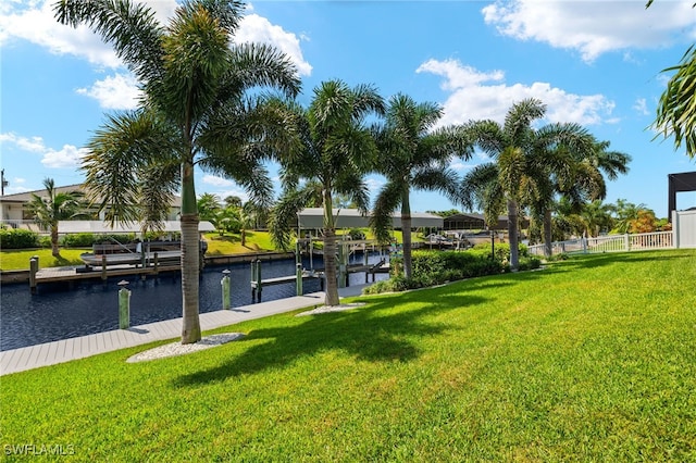 view of home's community featuring a dock, a lawn, and a water view