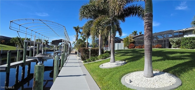 view of dock with a lawn and a water view