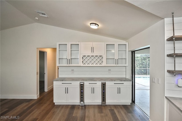 kitchen featuring white cabinets, dark hardwood / wood-style floors, and vaulted ceiling