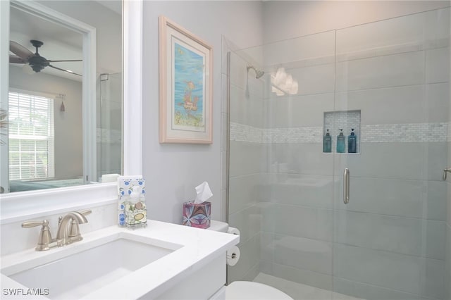 bathroom featuring vanity, toilet, an enclosed shower, and ceiling fan