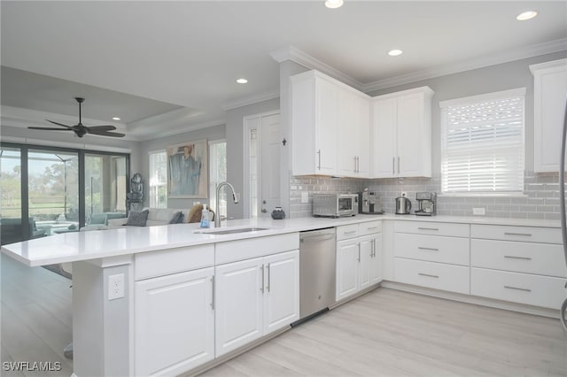 kitchen with white cabinetry, kitchen peninsula, dishwasher, and sink