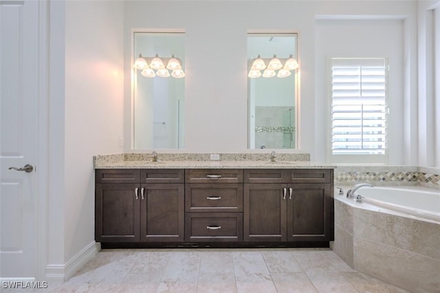 bathroom with vanity and tiled bath