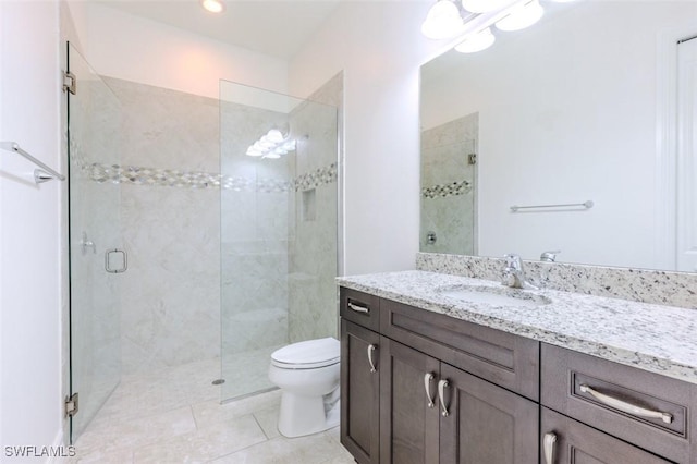 bathroom with tile patterned flooring, walk in shower, vanity, and toilet