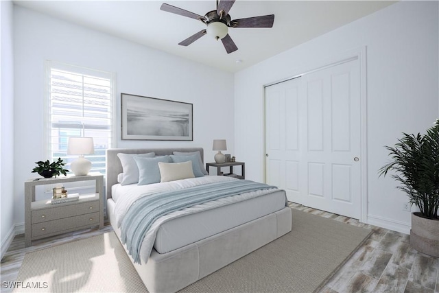 bedroom with ceiling fan, light hardwood / wood-style floors, and a closet