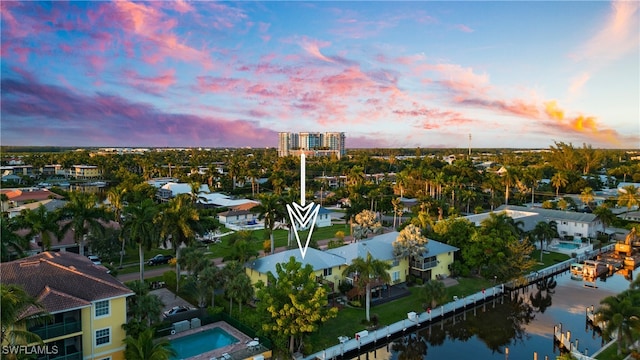 aerial view at dusk featuring a water view