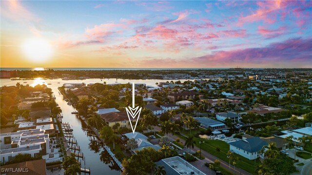 aerial view at dusk featuring a water view