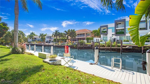 view of dock with a lawn and a water view