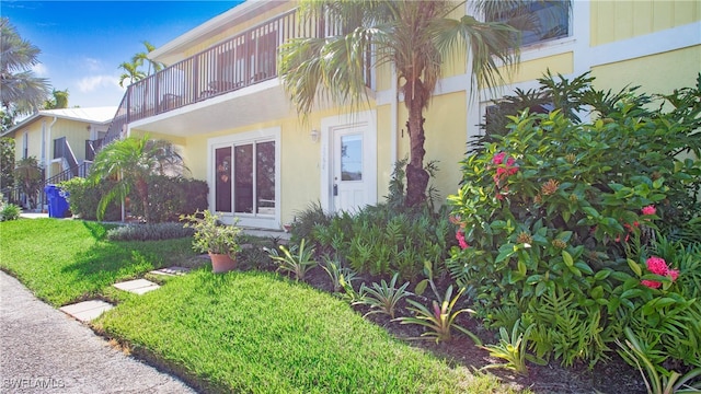 exterior space featuring a balcony and a front lawn