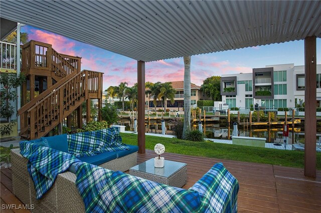 patio terrace at dusk with outdoor lounge area and a deck with water view