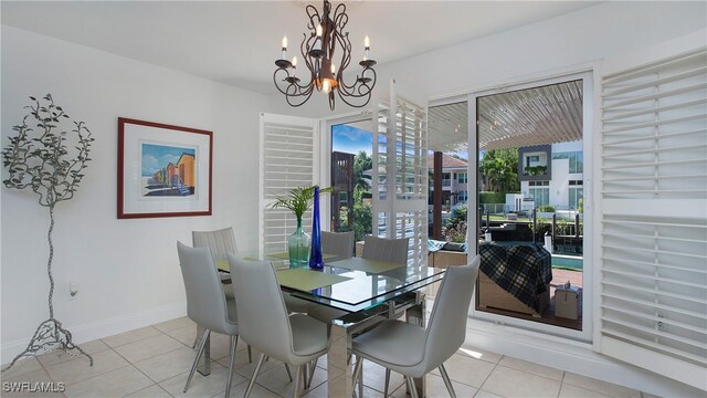 tiled dining space featuring an inviting chandelier