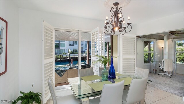 dining space featuring ceiling fan with notable chandelier and light tile patterned floors