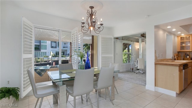 dining room with ceiling fan with notable chandelier, light tile patterned flooring, and sink