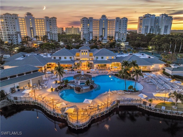 aerial view at dusk featuring a water view